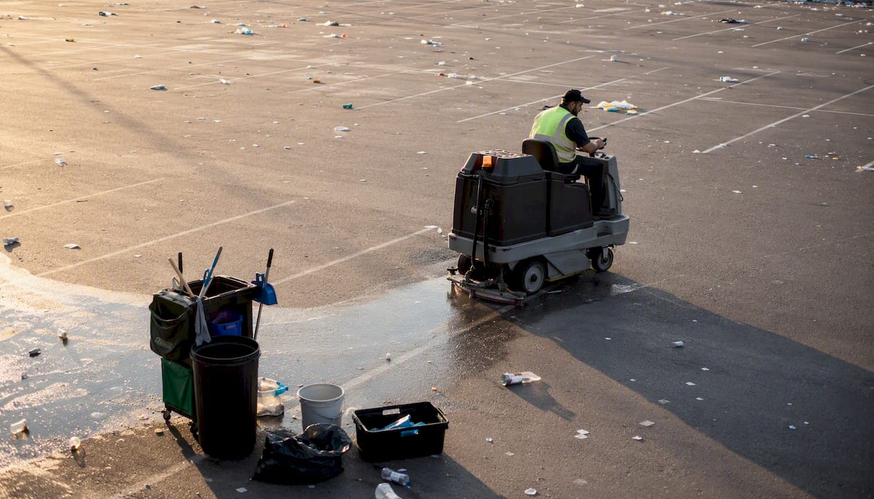 Operator riding floor scrubber cleaning venue floor