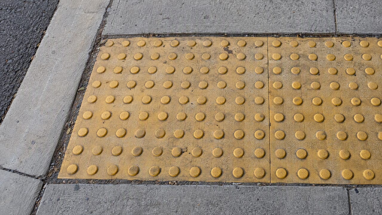 Raised tactile studs on a contrasting pad