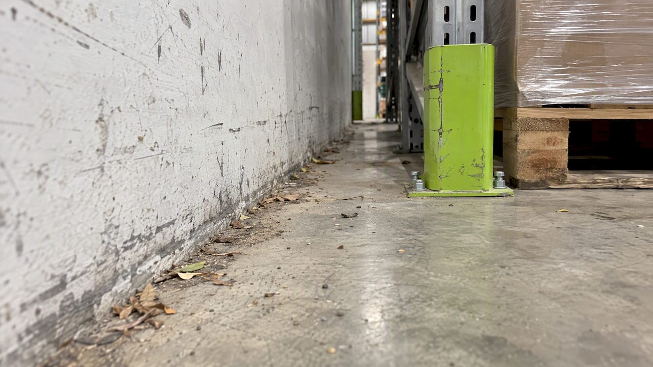 Dust and grit collected along a warehouse wall
